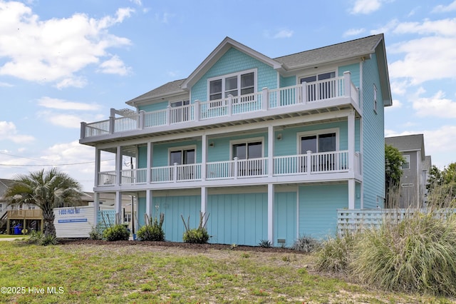 7502 9th Ave, North Topsail Beach, NC 28460 - view of front of house with a balcony, board and batten siding, and a shingled roof