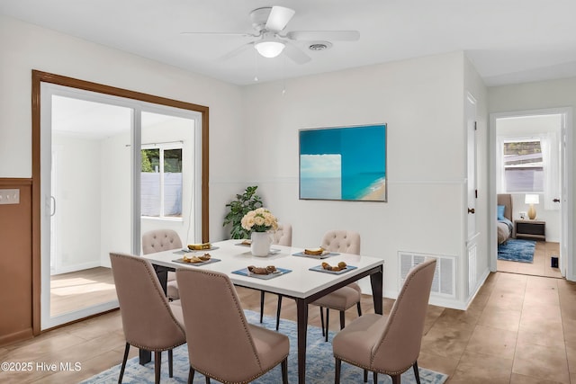 dining room with light tile patterned floors, a wealth of natural light, ceiling fan, and visible vents