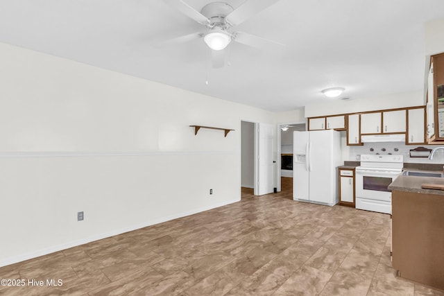 kitchen with a ceiling fan, dark countertops, a sink, under cabinet range hood, and white appliances