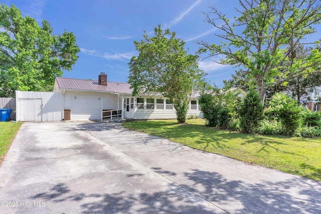 single story home with a front yard, driveway, a chimney, and metal roof