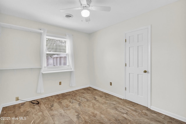 empty room with baseboards, a ceiling fan, and visible vents