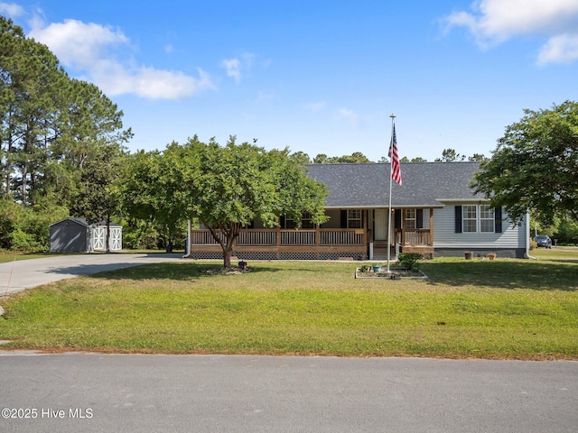 305 Cottontail Run, Newport, NC 28570 - view of front of property featuring a shingled roof, a front lawn, a shed, concrete driveway, and covered porch