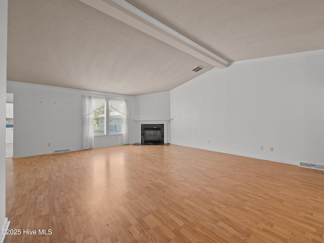 305 Cottontail Run, Newport, NC 28570 - unfurnished living room featuring a textured ceiling, visible vents, a glass covered fireplace, and light wood-style floors