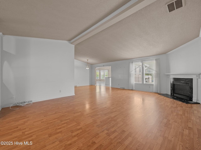 305 Cottontail Run, Newport, NC 28570 - unfurnished living room featuring visible vents, wood finished floors, a high end fireplace, a textured ceiling, and lofted ceiling with beams