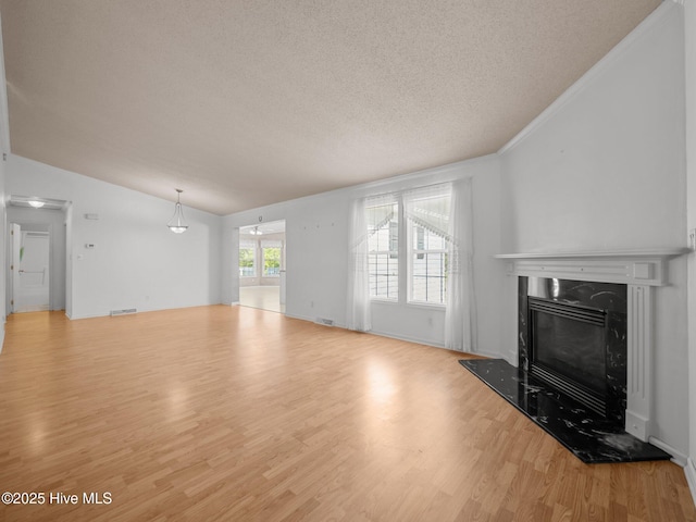 305 Cottontail Run, Newport, NC 28570 - unfurnished living room with a textured ceiling, visible vents, a fireplace, vaulted ceiling, and wood finished floors
