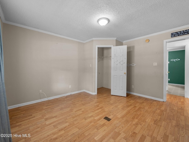 305 Cottontail Run, Newport, NC 28570 - unfurnished bedroom featuring a textured ceiling, crown molding, baseboards, a closet, and light wood finished floors
