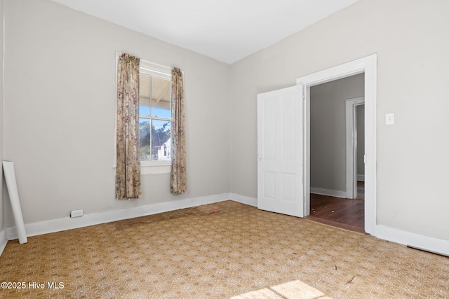 unfurnished room with baseboards