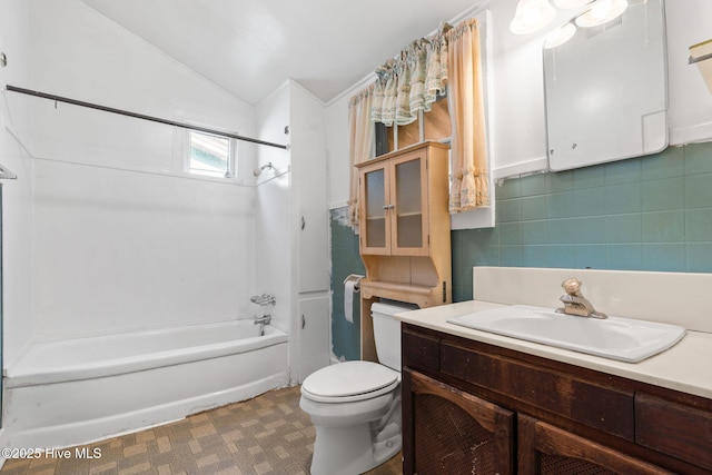 bathroom with toilet,  shower combination, vaulted ceiling, and vanity