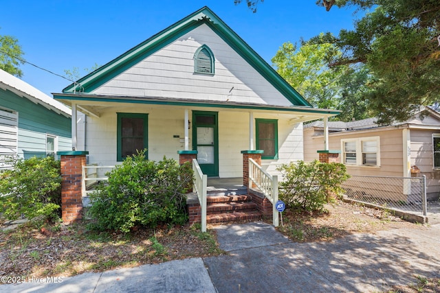 bungalow-style house featuring a porch and fence
