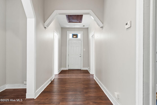 hall with baseboards and dark wood finished floors
