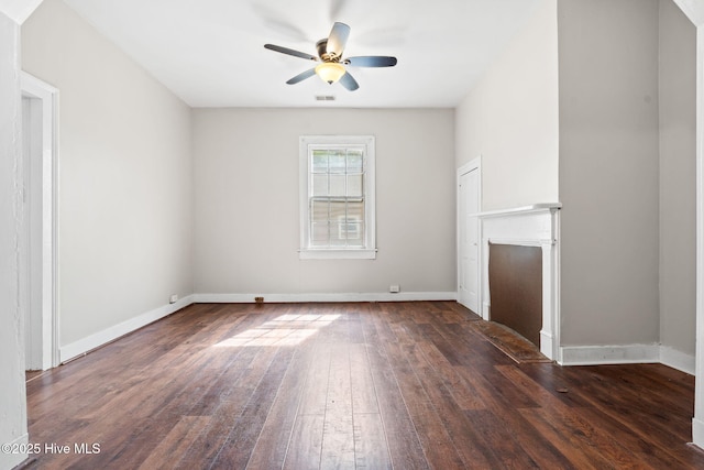unfurnished living room featuring ceiling fan, dark wood finished floors, baseboards, and visible vents