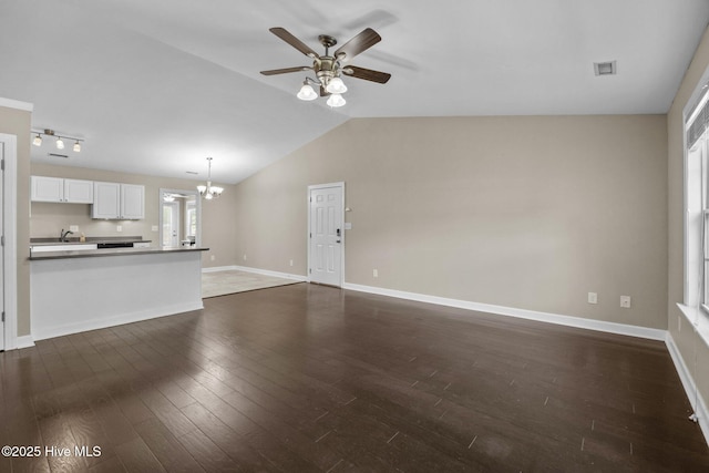 308 E Ashe St, Burgaw, NC 28425 - unfurnished living room with ceiling fan with notable chandelier, dark wood-type flooring, visible vents, vaulted ceiling, and baseboards