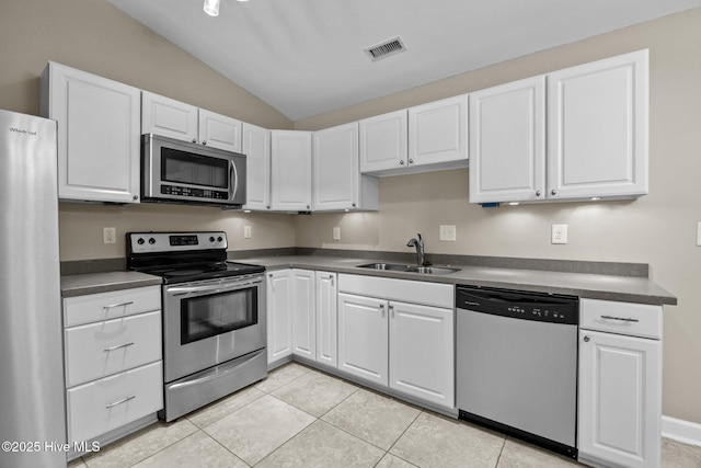 308 E Ashe St, Burgaw, NC 28425 - kitchen with a sink, dark countertops, stainless steel appliances, white cabinets, and lofted ceiling