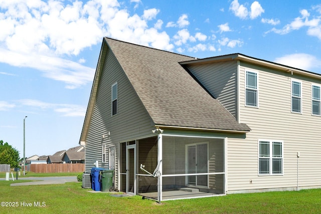 2202 Sweet Bay Dr Unit B, Greenville, NC 27834 - rear view of property featuring a sunroom, roof with shingles, a lawn, and central air condition unit
