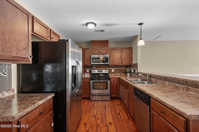 2202 Sweet Bay Dr Unit B, Greenville, NC 27834 - kitchen with stainless steel appliances, a sink, dark wood finished floors, brown cabinets, and a textured ceiling