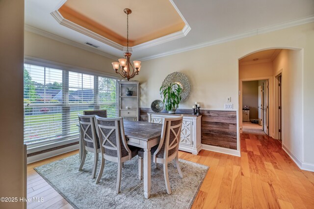 dining area featuring an inviting chandelier, arched walkways, crown molding, and visible vents