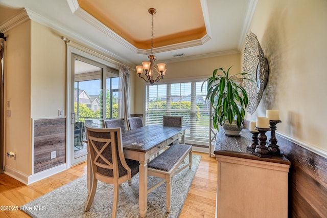 dining room with crown molding, a notable chandelier, visible vents, and a raised ceiling
