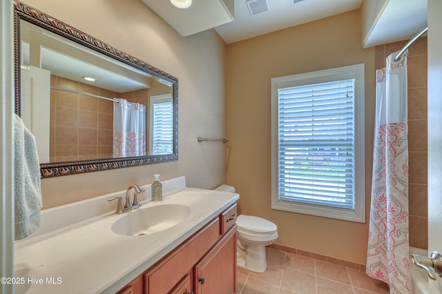 bathroom featuring visible vents, tile patterned flooring, vanity, toilet, and tiled shower