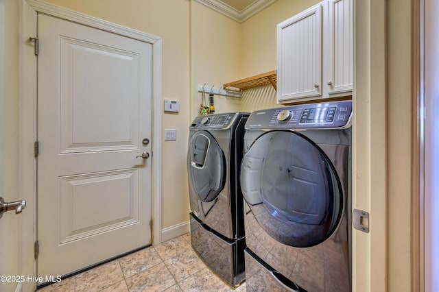 laundry area featuring baseboards, ornamental molding, cabinet space, and washing machine and clothes dryer