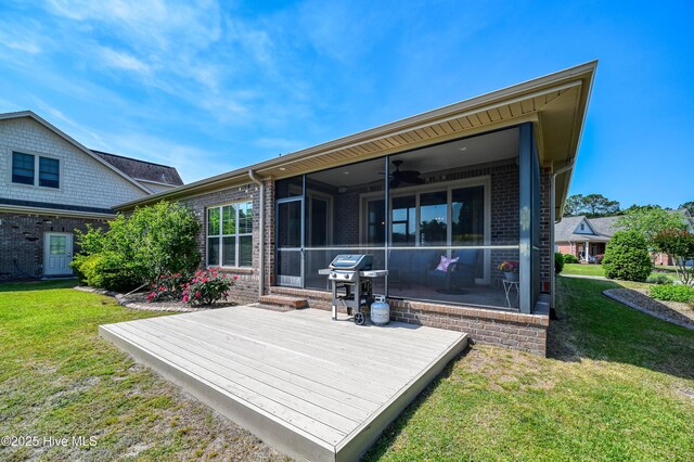 back of property featuring brick siding, a deck, a ceiling fan, and a sunroom