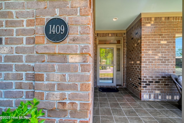 doorway to property with brick siding