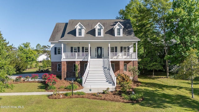 coastal home with a porch, brick siding, stairs, and a front yard