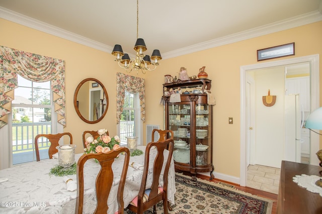 dining space with plenty of natural light, ornamental molding, and a notable chandelier