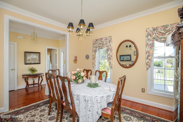 dining space featuring ornamental molding, wood finished floors, a notable chandelier, and a healthy amount of sunlight
