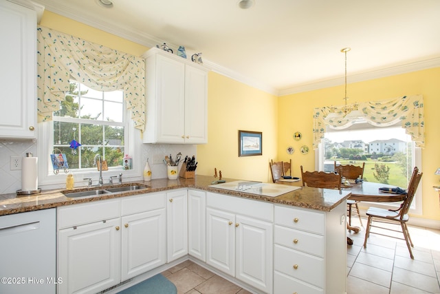kitchen featuring a sink, a peninsula, light tile patterned flooring, and a wealth of natural light