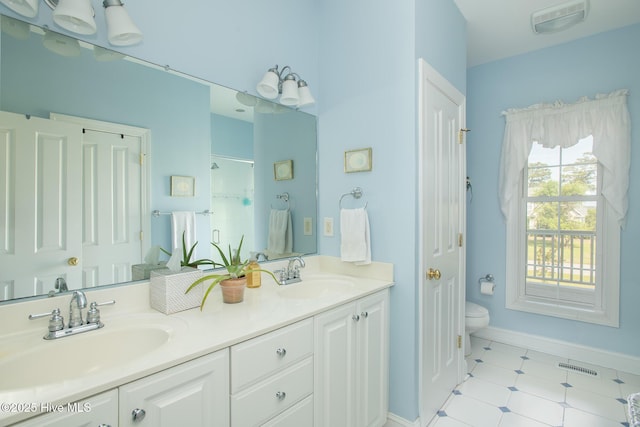 bathroom with visible vents, a sink, a stall shower, and double vanity