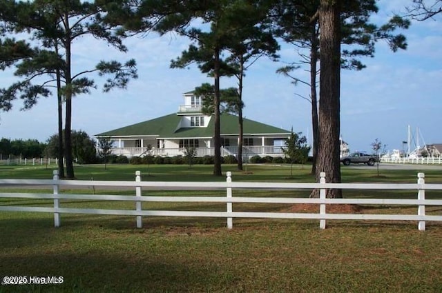 farmhouse-style home featuring fence and a front lawn