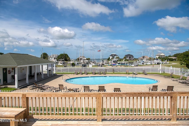 community pool featuring fence and a patio