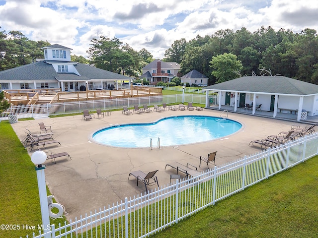 community pool featuring fence, a patio, and a yard