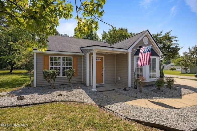 view of front of property with a shingled roof and a front lawn