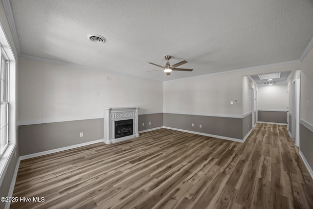 unfurnished living room with crown molding, a textured ceiling, ceiling fan, and wood finished floors