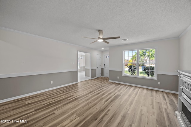 spare room with baseboards, a textured ceiling, ceiling fan, and wood finished floors