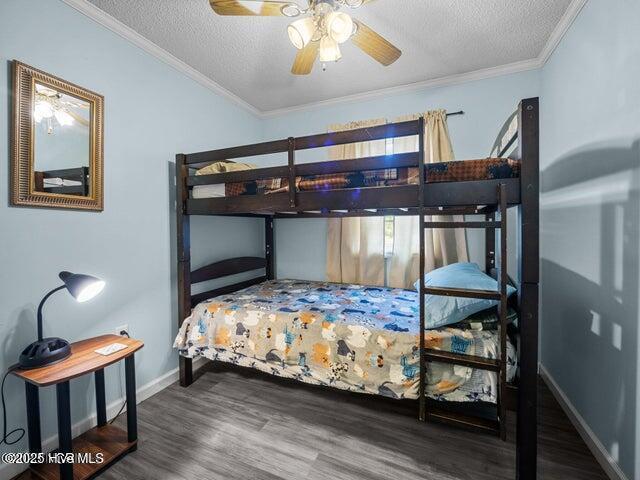 336 Old Folkstone Rd, Holly Ridge, NC 28445 - bedroom featuring crown molding, baseboards, a textured ceiling, and wood finished floors