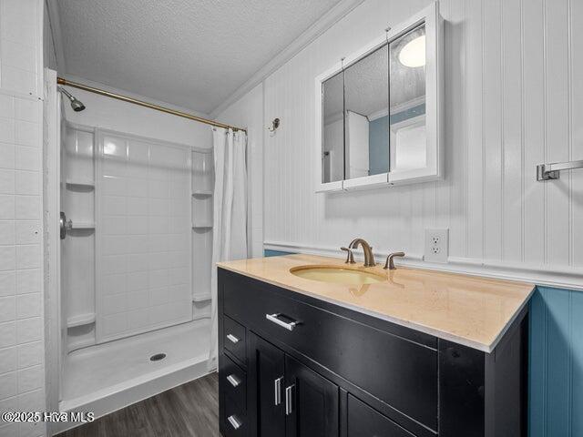 336 Old Folkstone Rd, Holly Ridge, NC 28445 - bathroom with crown molding, wood finished floors, a textured ceiling, and a shower with shower curtain