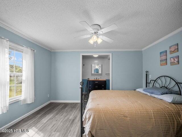 336 Old Folkstone Rd, Holly Ridge, NC 28445 - bedroom featuring crown molding, wood finished floors, baseboards, a textured ceiling, and a ceiling fan