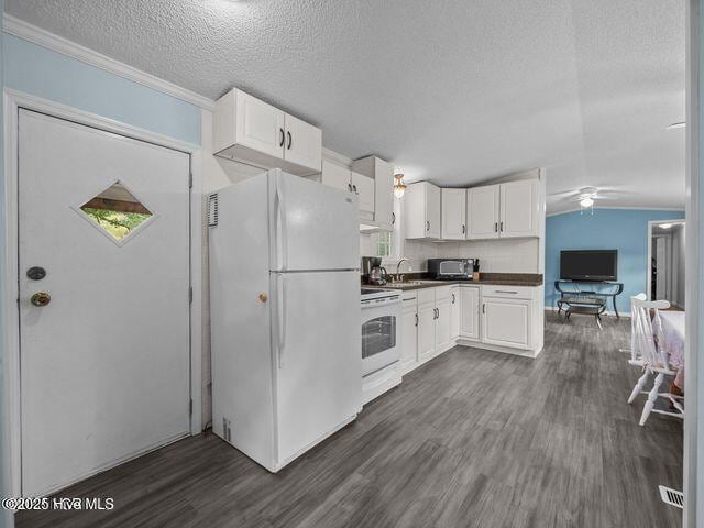 336 Old Folkstone Rd, Holly Ridge, NC 28445 - kitchen with white appliances, a textured ceiling, dark countertops, and dark wood finished floors