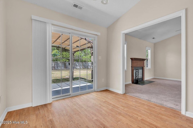 189 Queens Haven Rd, Hubert, NC 28539 - unfurnished living room with wood finished floors, visible vents, baseboards, and lofted ceiling