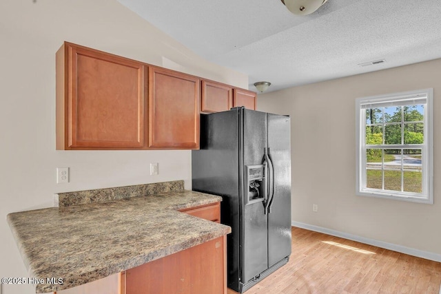 189 Queens Haven Rd, Hubert, NC 28539 - kitchen featuring brown cabinetry, baseboards, light wood finished floors, visible vents, and black fridge
