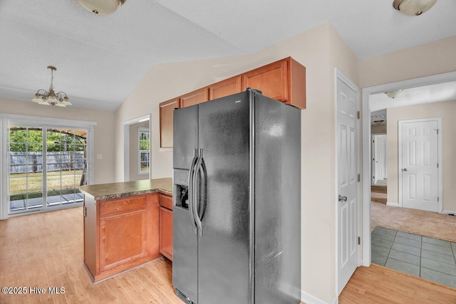 189 Queens Haven Rd, Hubert, NC 28539 - kitchen featuring lofted ceiling, black fridge, a peninsula, a chandelier, and light wood-type flooring