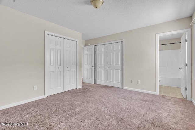 189 Queens Haven Rd, Hubert, NC 28539 - unfurnished bedroom featuring carpet flooring, ensuite bath, a textured ceiling, and multiple closets