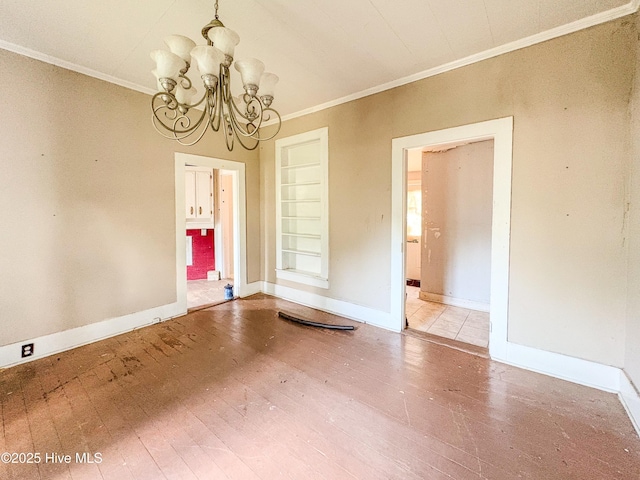 unfurnished dining area featuring crown molding, baseboards, hardwood / wood-style floors, and a chandelier