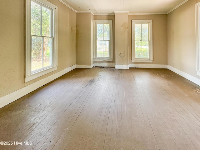 unfurnished room with wood-type flooring, ornamental molding, and baseboards