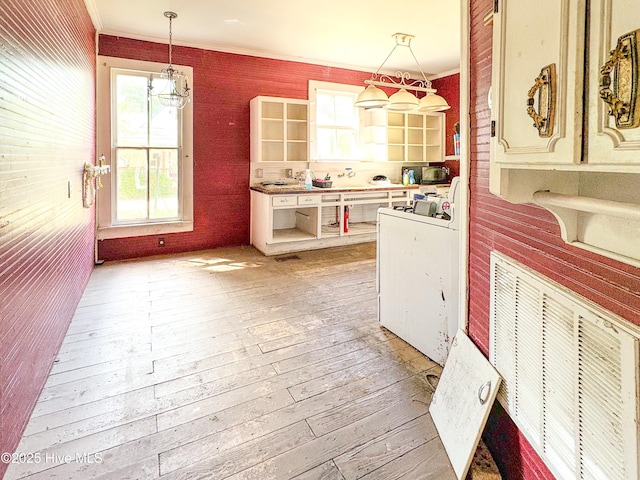 kitchen with crown molding, open shelves, light wood finished floors, and a wealth of natural light
