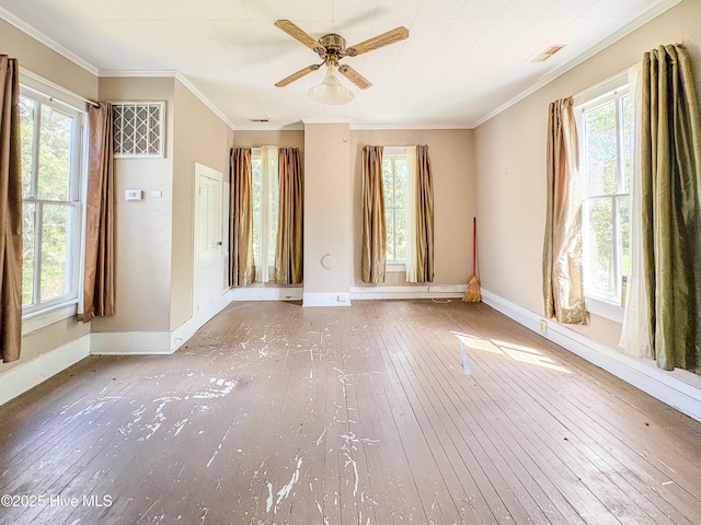 spare room with a healthy amount of sunlight, ornamental molding, and wood-type flooring