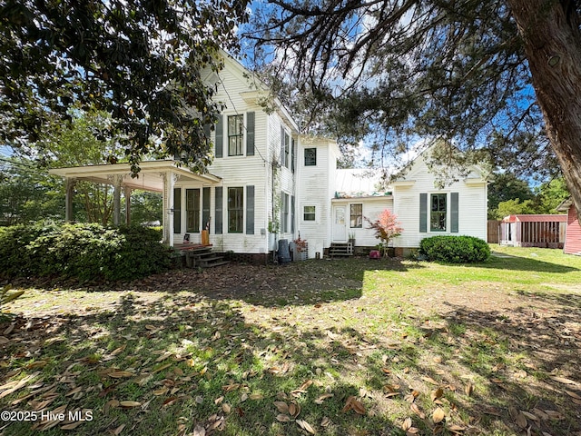 back of house with central air condition unit, a lawn, and entry steps