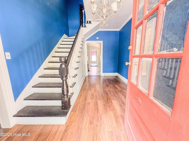 stairway with crown molding, baseboards, wood finished floors, and a notable chandelier